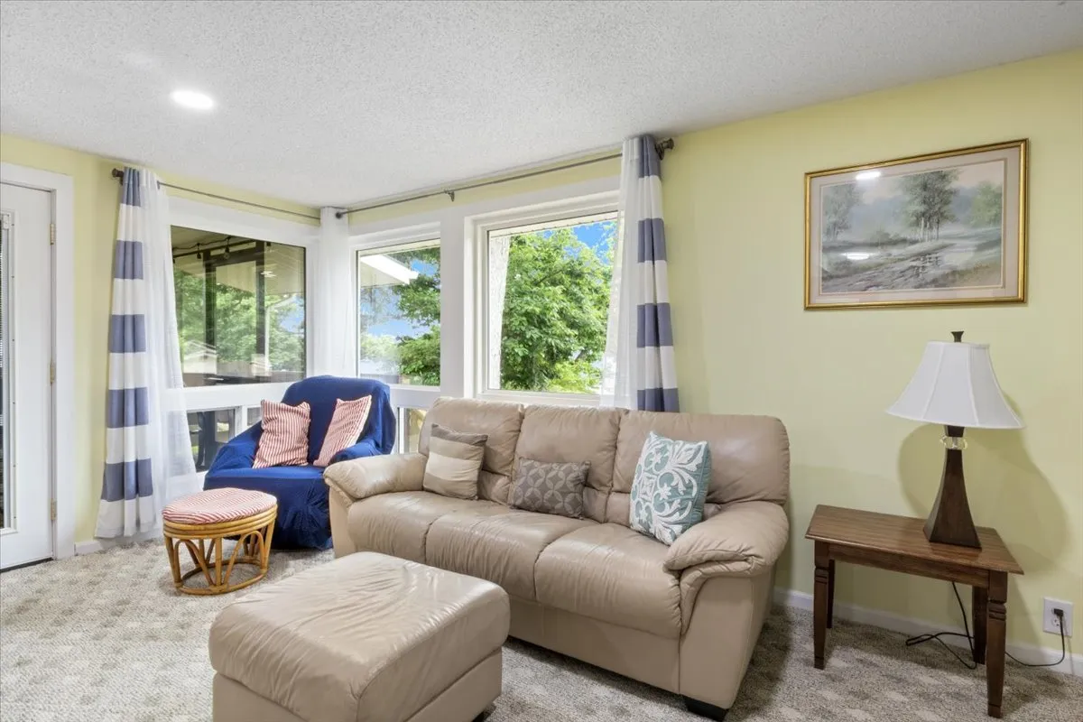 A detail-focused image of a leather sofa complemented by striped curtains and attractive wall art. The scene suggests a nook perfect for reading, sharing stories, or enjoying a quiet coffee, with an inviting and comfortable mood that encourages relaxation.