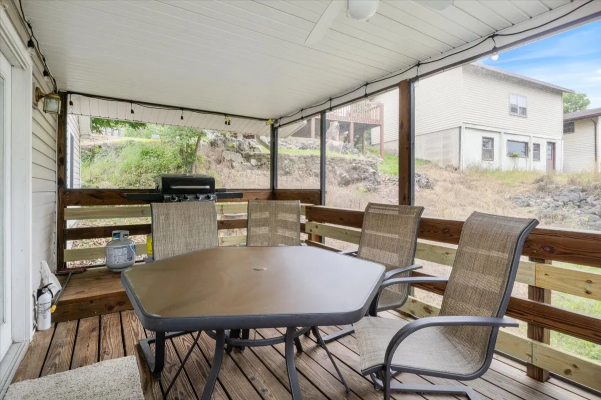 An inviting outdoor dining space with a table, chairs, grill, and green surroundings, suggesting relaxed meals and celebrations in the open air.